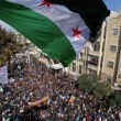 Syria independence flag flies over a large pathering of protesters in Idlib.