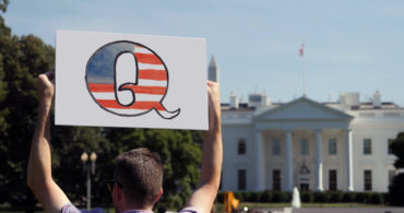 Man holding QAnon sign in front of the White House