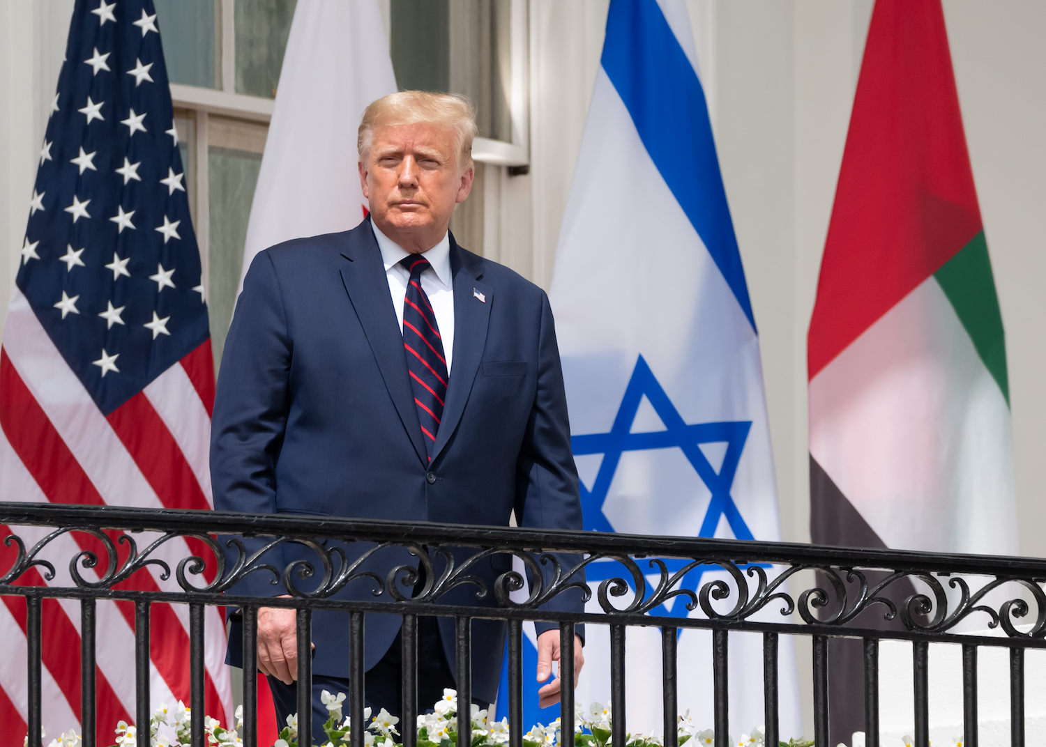 Donald Trump standing with the Israeli flag