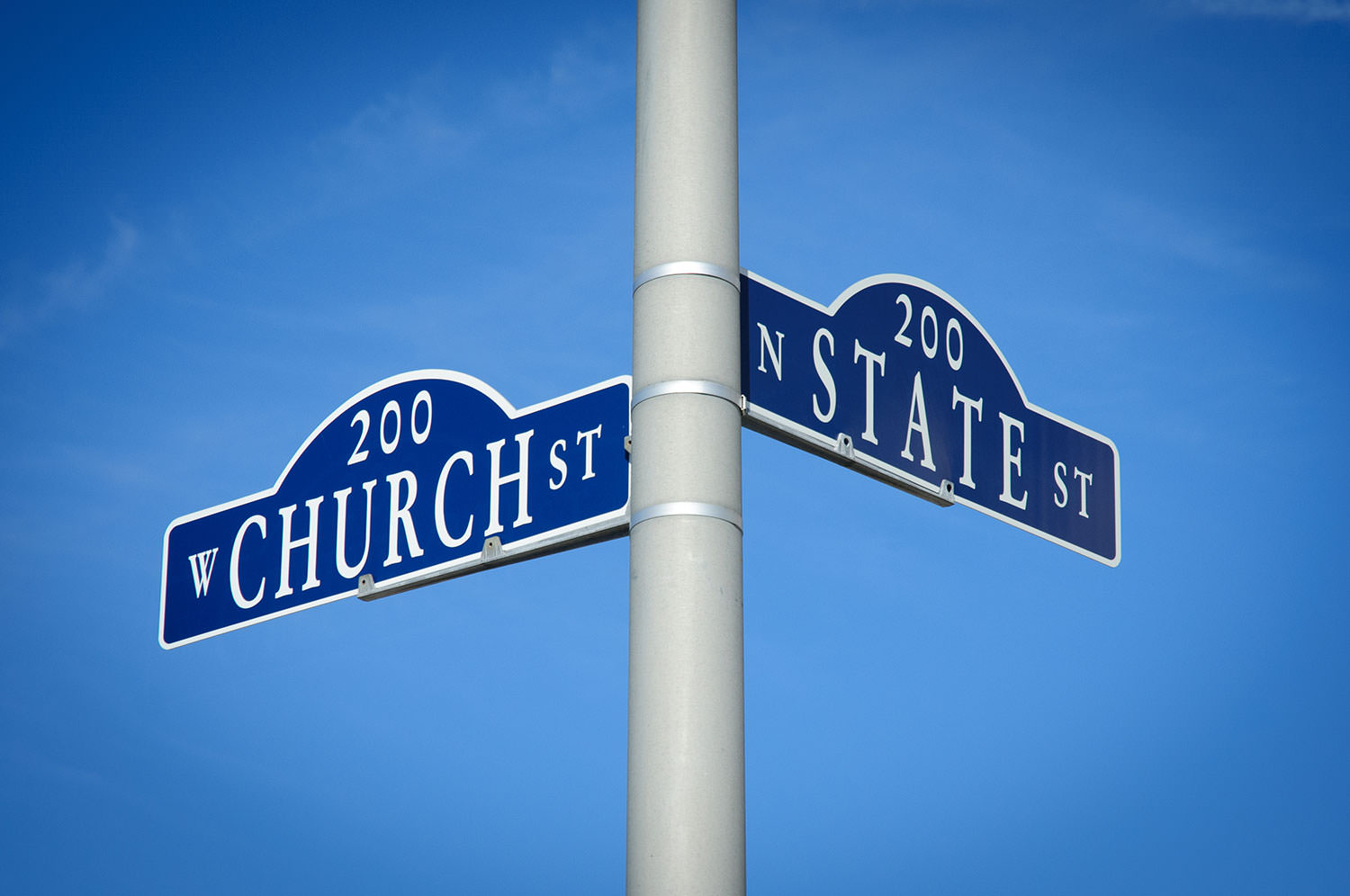 Street signs on a pole stating Church and State.