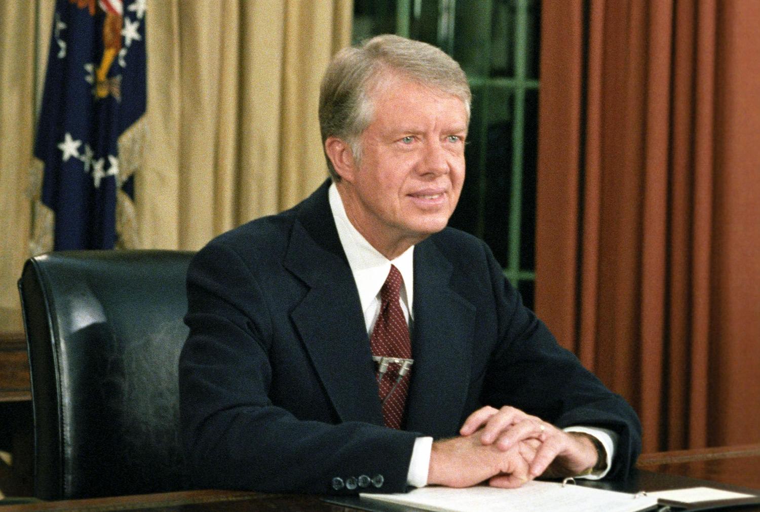 Photo of President Jimmy Carter at his desk in the Oval Office delivering his speech on inflation, October 24, 1978.