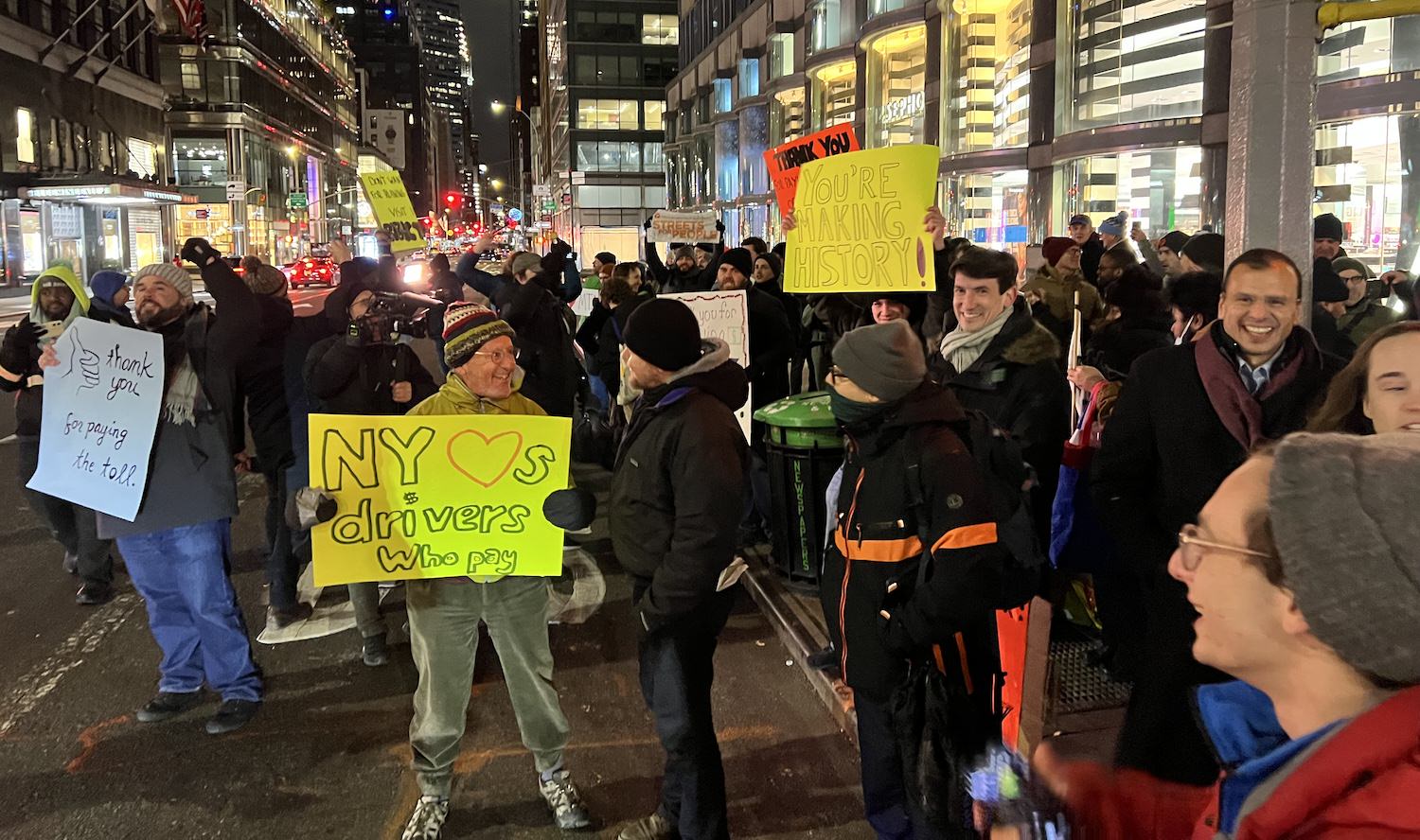 Congestion pricing supporters at Lexington Ave. and 60th Street, 12:03 a.m. Jan. 5, 2025. Author is at center, foreground, holding yellow sign. Photo: Sproule Love.