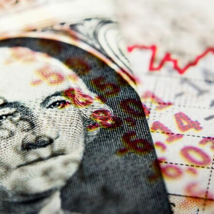 Stock Market Graph and dollar bill. Red trend line indicates the stock market recession.