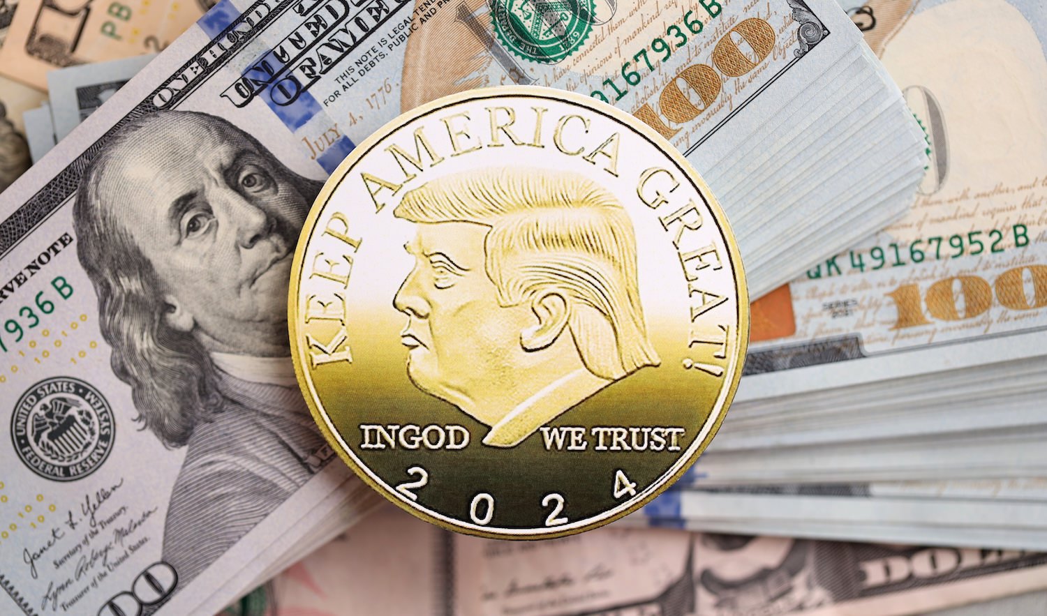 trump-coin Trump gold coin on big amount of US dollar money bills banknotes close up